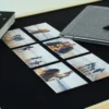 Sześć personalizowanych foto magnesów z rodzinnymi zdjęciami ułożonych na czarnej powierzchni obok notesu, rysika i książki – elegancka dekoracja oraz praktyczny pomysł na prezent.